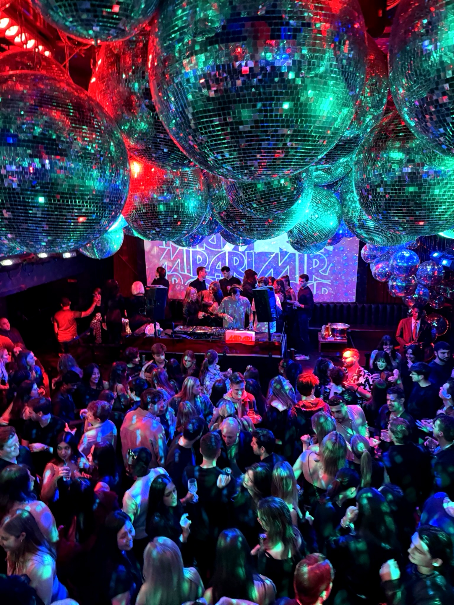 Nightclub scene with disco balls and crowd